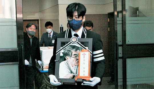 지난 8일 별세한 김지하 시인의 발인식이 11일 오전 강원 원주시 원주세브란스기독병원 장례식장에서 엄수됐다. 차남인 김세희 토지문화재단 이사장이 고인의 영정을 들고 장례식장을 나오고 있다.  뉴시스