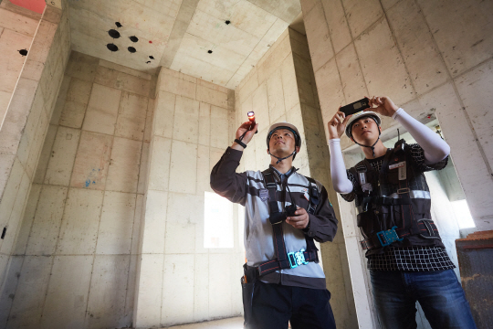 한화건설 직원들이 모바일 안전관리 시스템‘HS2E’를 활용해 현장을 점검하고 있다.  한화그룹 제공