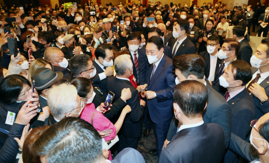윤석열 대통령이 11일 오후 서울 롯데호텔에서 열린 재외동포 초청 리셉션에서 참석자들에게 둘러싸여 인사를 나누고 있다.  연합뉴스