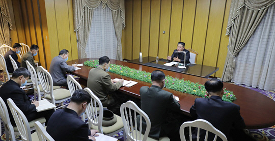 김정은 북한 국무위원장이 12일 국가비상방역사령부를 방문해 코로나19 확진자 상황을 보고받고 방역 관련 지시를 했다고 조선중앙통신이 13일 보도했다. 참석자들이 마스크를 끼고 거리를 두고 앉아서 김 위원장의 지시를 받아적고 있다. 연합뉴스
