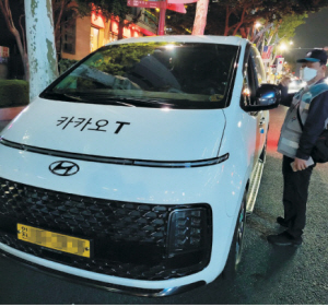 12일 오후 11시 30분 역삼역 5번출구 인근에서 서울시 교통지도단속원이 1차선 도로에 정차 중인 인천 택시 기사에게 목적지 등을 묻고 있다.