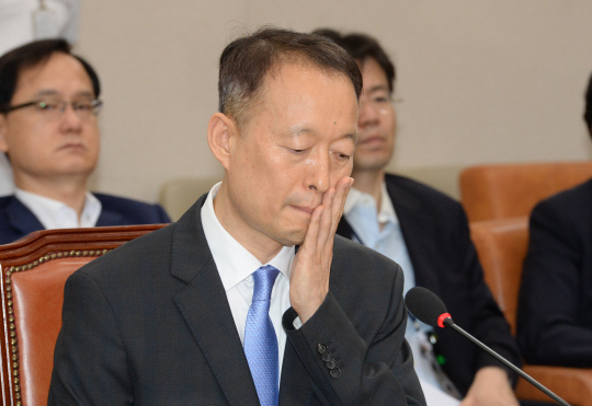 백운규 전 산업통상자원부 장관이 지난 2017년 7월 19일 국회에서 열린 자신의 인사청문회에서 심각한 표정을 지으며 얼굴을 만지고 있다. 김호웅 기자