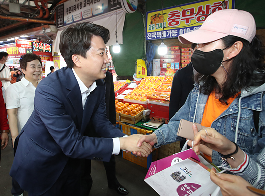 이준석(왼쪽) 국민의힘 대표가 지난 16일 제주시 동문시장에서 유권자와 악수하고 있다. 연합뉴스