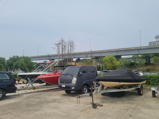 19일 서울 마포구 망원 한강공원 트레일러 주차장에 장기간 계류된 것으로 보이는 레저용 선박 세 대가 나란히 서 있다.