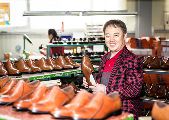 김원길 바이네르 대표가 24일 경기 고양시 본사에서 구두 제품을 들어 보이고 있다.   바이네르 제공