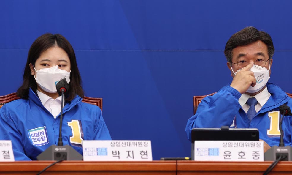 박지현(왼쪽) 더불어민주당 공동비상대책위원장이 25일 오전 국회에서 열린 선거대책위원회 합동회의에 참석해 당내 ‘586 용퇴론’ 등을 주장한 이후 윤호중 공동비대위원장과 불편한 듯 어두운 표정으로 서로 다른 곳을 응시하고 있다.  국회사진기자단