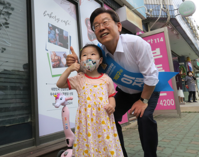 국회의원 보궐선거 인천 계양을에 출마한 이재명 더불어민주당 후보가 25일 오후 지역구인 인천 계양구 장기동 아파트 단지에서 아이와 사진 촬영을 하면서 엄지를 들어 보이고 있다. 뉴시스