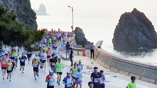 울릉도 전국마라톤대회는 아름다운 신비의 섬 울릉도의 해안도로를 따라 달리는 환상적인 코스로 유명하다.  특히 올해는 처음으로 울릉도 해안 도로를 따라 일주하는 풀코스가 진행돼 관심을 모으고 있다.  사진은 지난 2018년 열린 ‘제15회 울릉도 전국마라톤대회’에서 건각들이 울릉도의 비경을 바라보며 힘차게 달리고 있는 모습.    울릉군 제공