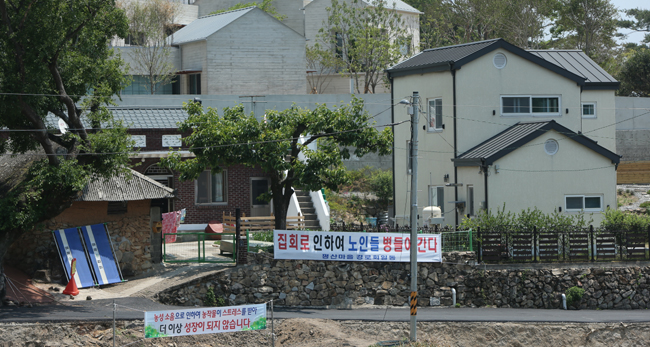 지난 25일 경남 양산시 하북면 지산리 평산마을 문재인 전 대통령 사저 앞에 문 전 대통령 반대단체 집회, 1인 시위에 항의하는 마을 주민 현수막이 내걸려 있다. 연합뉴스