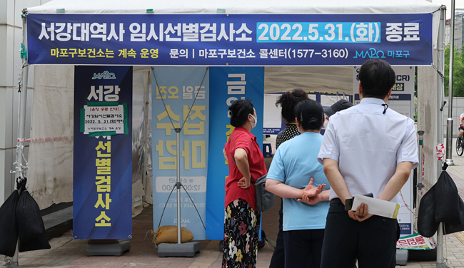 코로나19 확진자 감소에 따라 6월부터 임시선별검사소 운영이 중단되는 가운데, 31일 오전 서울 마포구 서강선별진료소에 시민 5~6명이 코로나19 검사를 위해 줄을 서 있다. 연합뉴스