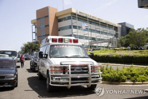 도미니카공화국 환경장관이 6일(현지시간) 집무실에서 살해된 후 환경부 건물 앞에 구급차가 지나고 있다.  EPA 연합뉴스