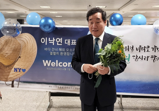 이낙연 전 더불어민주당 대표가 7일(현지시간) 미국 워싱턴 인근의 덜레스 공항을 통해 미국으로 입국, 지지자들이 준 꽃다발을 들고 인사하고 있다. 연합뉴스
