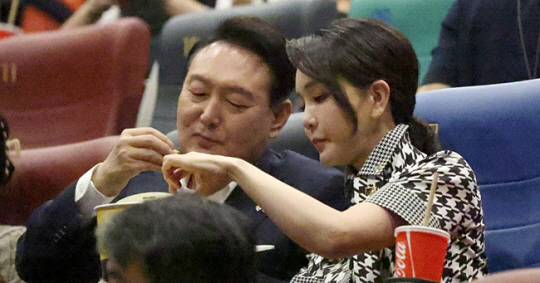 윤석열 대통령과 부인 김건희 여사가 12일 오후 서울 성동구 한 영화관에서 영화 ‘브로커’ 관람 전 팝콘을 먹고 있다. 대통령실 제공