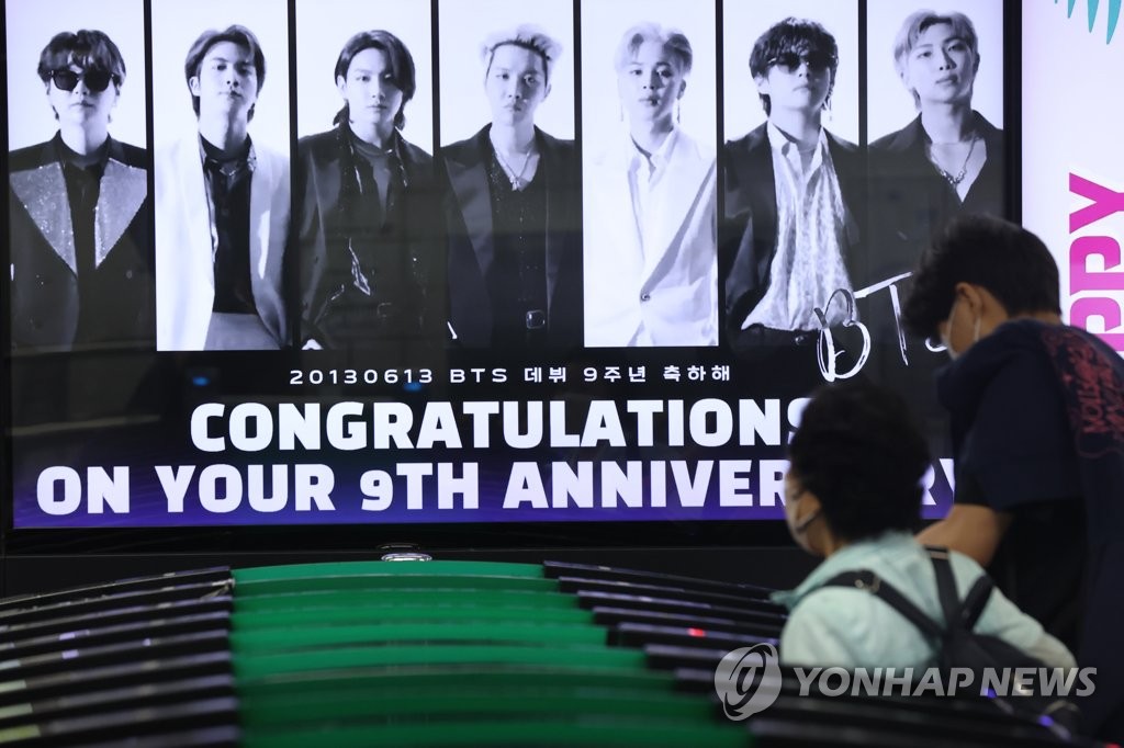 그룹 방탄소년단(BTS)이 팀 활동 잠정 중단 선언한 15일 오후 서울 지하철 2호선 강남역에 데뷔 9주년 축하 영상이 상영되고 있다. 연합뉴스