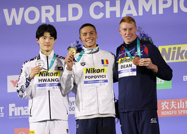 황선우(왼쪽)가 21일 오전(한국시간) 헝가리 부다페스트의 두나 아레나에서 세계수영선수권대회 남자 자유형 200m 은메달을 손에 든 채 미소 짓고 있다. 황선우는 1분44초47로 한국 신기록을 갈아치웠다.  로이터연합뉴스