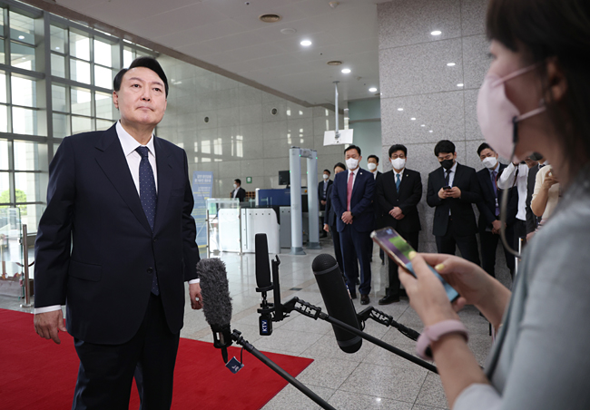 윤석열 대통령이 21일 서울 용산 대통령실 청사로 출근하며 취재진 질문을 듣고 있다. 뉴시스·대통령실통신사진기자단
