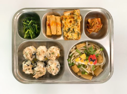 한 현직 영양사가 문화일보에 제공한 급식 메뉴 사진. 동물성 재료를 최소화하고 참치마요주먹밥, 앵그리버드어묵우동, 유채나물무침, 야채춘권과 칠리소스, 맛남대파토스트, 배추김치 등으로 메뉴가 구성됐다.