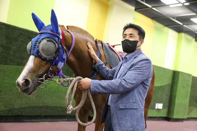 서인석 조교사가 경기 과천의 서울경마공원에서 경주를 앞두고 ‘누비고’와 함께 출전을 기다리고 있다.  한국마사회 제공
