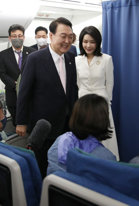 윤석열 대통령과 부인 김건희 여사가 27일(현지시간) 스페인 마드리드로 향하는 공군1호기에서 취재진과 인사하고 있다. 뉴시스