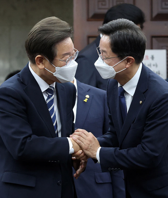 이재명(왼쪽) 더불어민주당 의원과 당대표 출마를 선언한 강병원 의원이 30일 오후 국회에서 열린 의원총회에서 악수하고 있다. 뉴시스