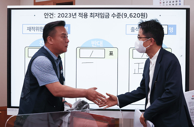 세종시 정부세종청사 최저임금위원회 회의실에서 29일 열린 제8차 최임위 전원회의에서 내년도 최저임금이 9620원으로 의결된 뒤 30일 새벽 근로자 위원인 이동호 한국노총 사무총장(왼쪽)과 박준식 위원장이 악수를 하고 있다. 연합뉴스