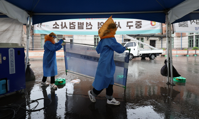 서울 중구청 관계자와 의료진이 지난달 30일 운영이 종료된 서울역광장 코로나19 임시선별검사소 철거 작업을 하고 있다. 연합뉴스