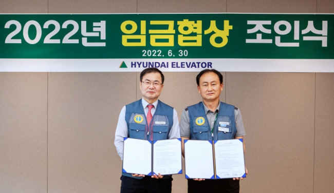 조재천 현대엘리베이터 대표이사가 충북 충주 본사에서 손만철 노조위원장과 ‘2022년 임금협상 조인식’을 하고 있다.  현대엘리베이터 제공