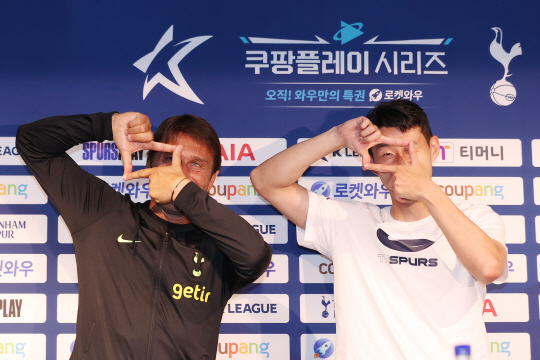 토트넘 홋스퍼의 손흥민(오른쪽)이 안토니오 콘테 감독과 12일 서울월드컵경기장에서 열린 ‘쿠팡플레이 시리즈’ 친선경기 기자회견에서 카메라 세리머니를 선보이고 있다. 연합뉴스