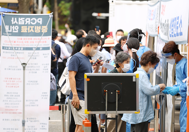 12일 오전 서울 강남구보건소에 마련된 선별진료소에서 코로나19 검사를 받으려는 시민들이 순서를 기다리고 있다. 연합뉴스