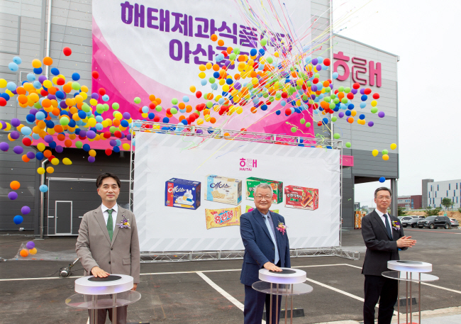 12일 충남 아산시 음봉면에서 열린 해태제과 아산공장 준공 제막식에서 윤영달(가운데) 크라운해태제과 회장과 윤석빈(오른쪽) 크라운해태홀딩스 대표이사, 신정훈(왼쪽) 해태제과 대표이사가 기념사진을 찍고 있다.  해태제과 제공