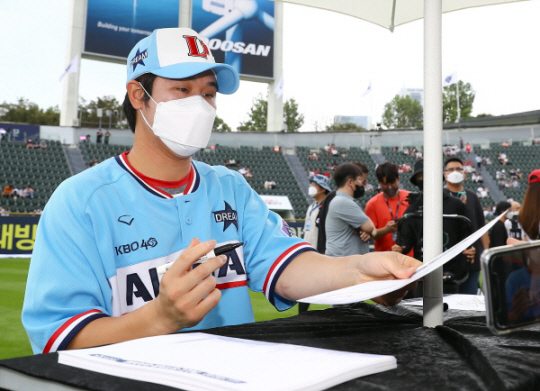 SSG의 최정이 16일 오후 잠실구장에서 열린 신한은행 쏠(SOL) KBO리그 올스타전 팬사인회에 참석해 사인한 종이를 팬에게 전달하고 있다. SSG 제공