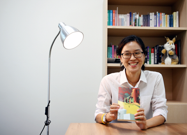 정보라 작가가 지난 15일 경기 고양시 그린북에이전시 사무실에서 폴란드 과학소설(SF) 거장 스타니스와프 렘의 ‘우주 순양함 무적호’ 폴란드어판을 들고 환하게 웃고 있다.  윤성호 기자