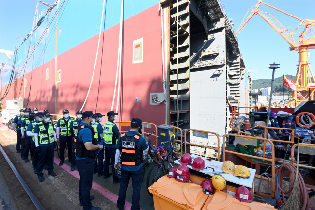 대우조선해양 하청노조 파업 51일째를 맞은 22일 오전 경남 거제시 옥포조선소 1독 농성 현장에 경찰이 배치돼 있다. 금속노조 거제·고성·통영 조선하청지회와 21개 대우조선 사내협력업체는 이날 오전 8시부터 막바지 협상을 벌이고 있다.   김호웅 기자