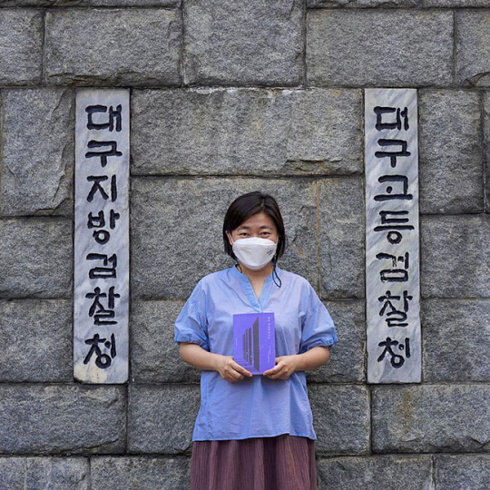자신이 근무하는 대구지검 정문 앞서 출간한 책을 들고 기념사진을 찍은 임은정 검사. 임 검사 페이스북 캡처