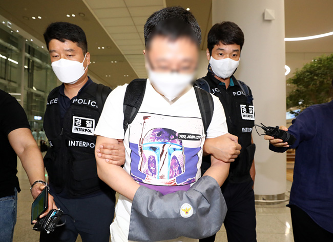 국내 최대 성매매 알선 사이트를 운영한 혐의를 받는 박모 A씨가 22일 오전 인천국제공항 제2여객터미널을 통해 국내로 송환되고 있다. 뉴시스