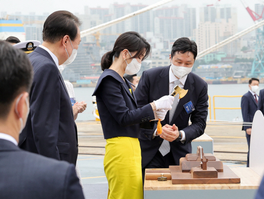 윤석열 대통령 부인 김건희 여사가 28일 울산 현대중공업에서 열린 정조대왕함 진수식에서 진수줄을 절단하고 있다. 뉴시스