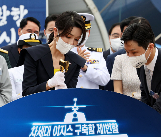 윤석열 대통령 부인 김건희(왼쪽) 여사가 28일 울산 현대중공업에서 열린 정조대왕함 진수식에서 황금색 도끼로 진수줄을 절단하고 있다. 뉴시스