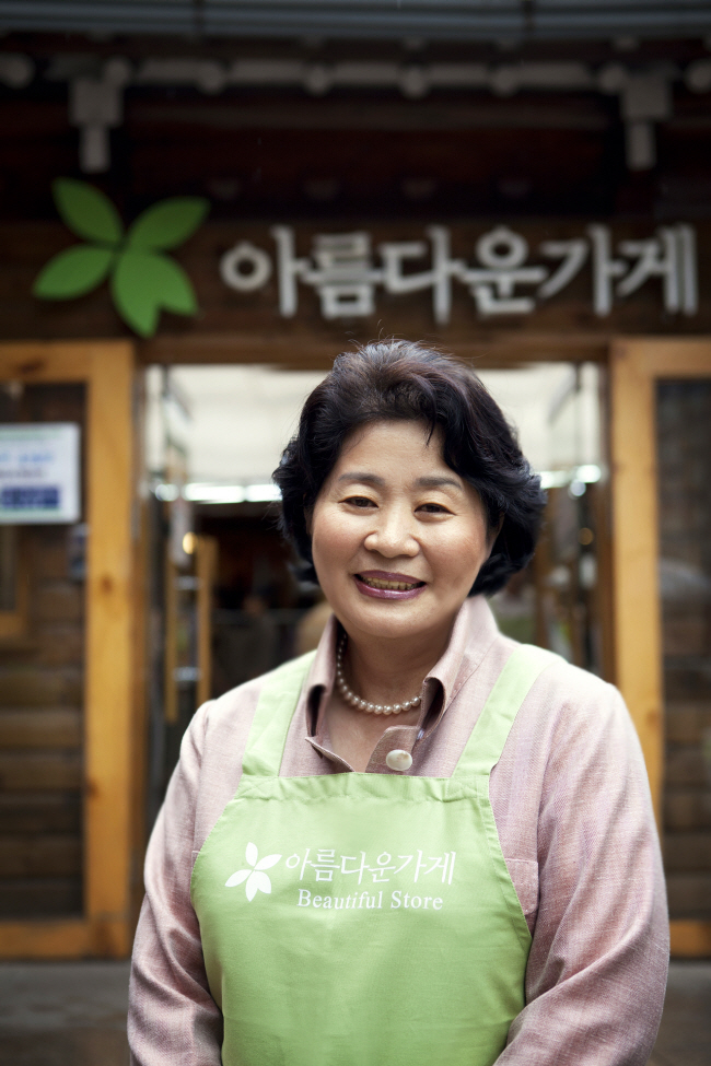지난해 아름다운가게 이사장 재임 시 봉사활동을 하다 아름다운가게 앞에서 포즈를 취하고 있는 홍명희 전 이사장. 아름다운가게 제공