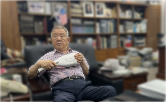 박유재 (주)에넥스 명예회장이 인터뷰 도중 마사지 건을 이용해 마사지하는 동작을 보여 주고 있다.