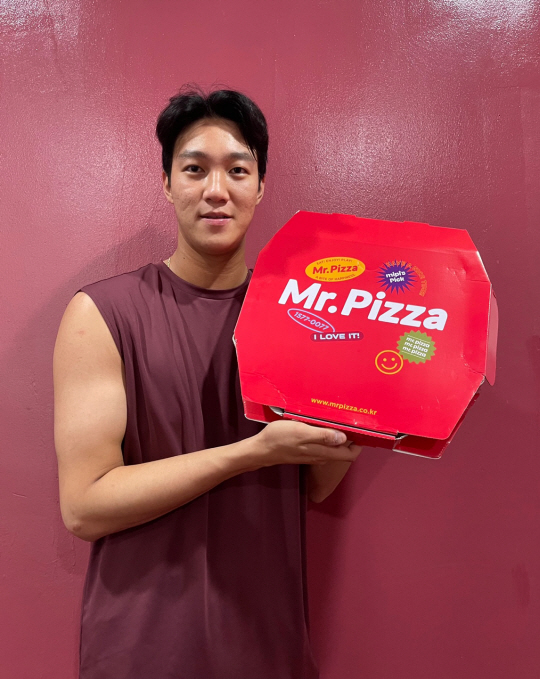 키움의 안우진이 4일 고척스카이돔에서 열린 SSG전을 앞두고 동료들과 프런트에게 돌린 피자를 들고 기념촬영을 하고 있다. 키움 제공