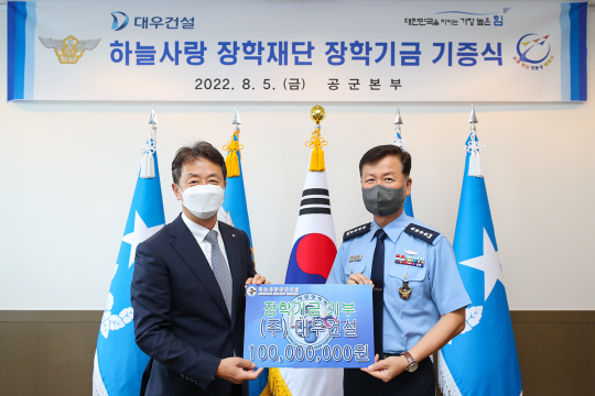 백정완(왼쪽) 대우건설 사장이 지난 5일 서울 영등포구 공군호텔에서 정상화 공군참모총장에게 하늘사랑 장학재단 장학기금 1억  원을 기증하고 있다. 대우건설 제공