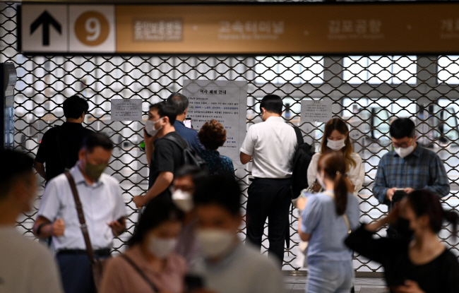 9일 오전 침수로 폐쇄된 서울 동작구 지하철 9호선 동작역사 앞에서 출근길 시민들이 휴대전화 등으로 대체 교통수단을 알아보고 있다. 윤성호 기자