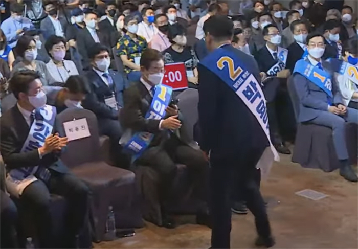 지난 7일 제주 지역 합동연설회에서 박용진 의원이 악수를 청하자 이재명 의원이 휴대전화를 응시한 채 손만 내밀고 있다. 델리민주 유튜브 캡처