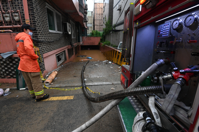 9일 오전 ‘반지하 장애 가족 참변’이 발생한 서울 관악구의 한 빌라 앞에서 소방관들이 배수 작업을 하고 있다. 김호웅 기자