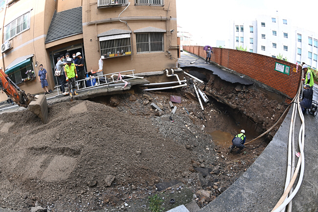 집중호우로 싱크홀이 발생한 서울 양천구 신월동 한 주택가에서 10일 오전 구청 관계자들이 복구 작업을 진행하고 있다. 김호웅 기자