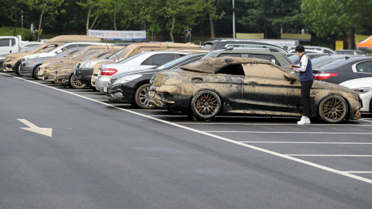 중부지방 집중호우로 발생한 차량 피해 추정손해액이 1400억원을 돌파한 가운데 14일 오전 경기 과천시 서울대공원 주차장에 침수 당시 뒤집어 쓴 진흙이 그대로 남아 있는 고가의 외제차량 등이 모여있다. 뉴시스