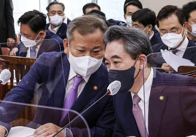 이상민(왼쪽) 행정안전부 장관과 윤희근 경찰청장이 18일 오전 국회 행정안전위원회에 출석해 대화를 나누고 있다.   국회사진기자단