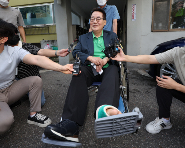 지난달 산행 중 발목 골절상을 입은 박지원 전 국가정보원장이 16일 오전 검찰이 여의도 자택 압수수색을 한 이후 휠체어를 타고 집에서 나오며 기자들의 질문에 답하고 있다. 연합뉴스
