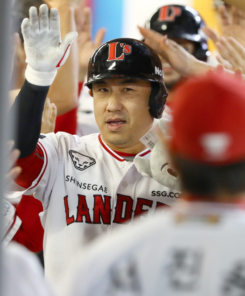 SSG의 김강민이 23일 인천SSG랜더스필드에서 열린 삼성과의 홈경기에서 8회 말 쐐기 3점 홈런을 터뜨린 뒤 더그아웃에서 동료들의 축하를 받고 있다. SSG 제공