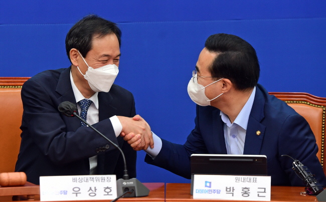 우상호(왼쪽) 더불어민주당 비상대책위원장과 박홍근 원내대표가 26일 오전 국회에서 열린 마지막 비대위 회의를 마친 뒤 악수를 하고 있다.  국회사진기자단